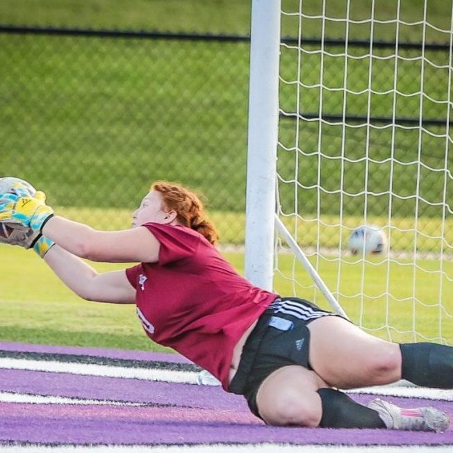 Milan's Karle Parish makes a diving save against Lexington during a high school girls soccer match at Johnnie Hale Stadium on Aug. 25, 2026.